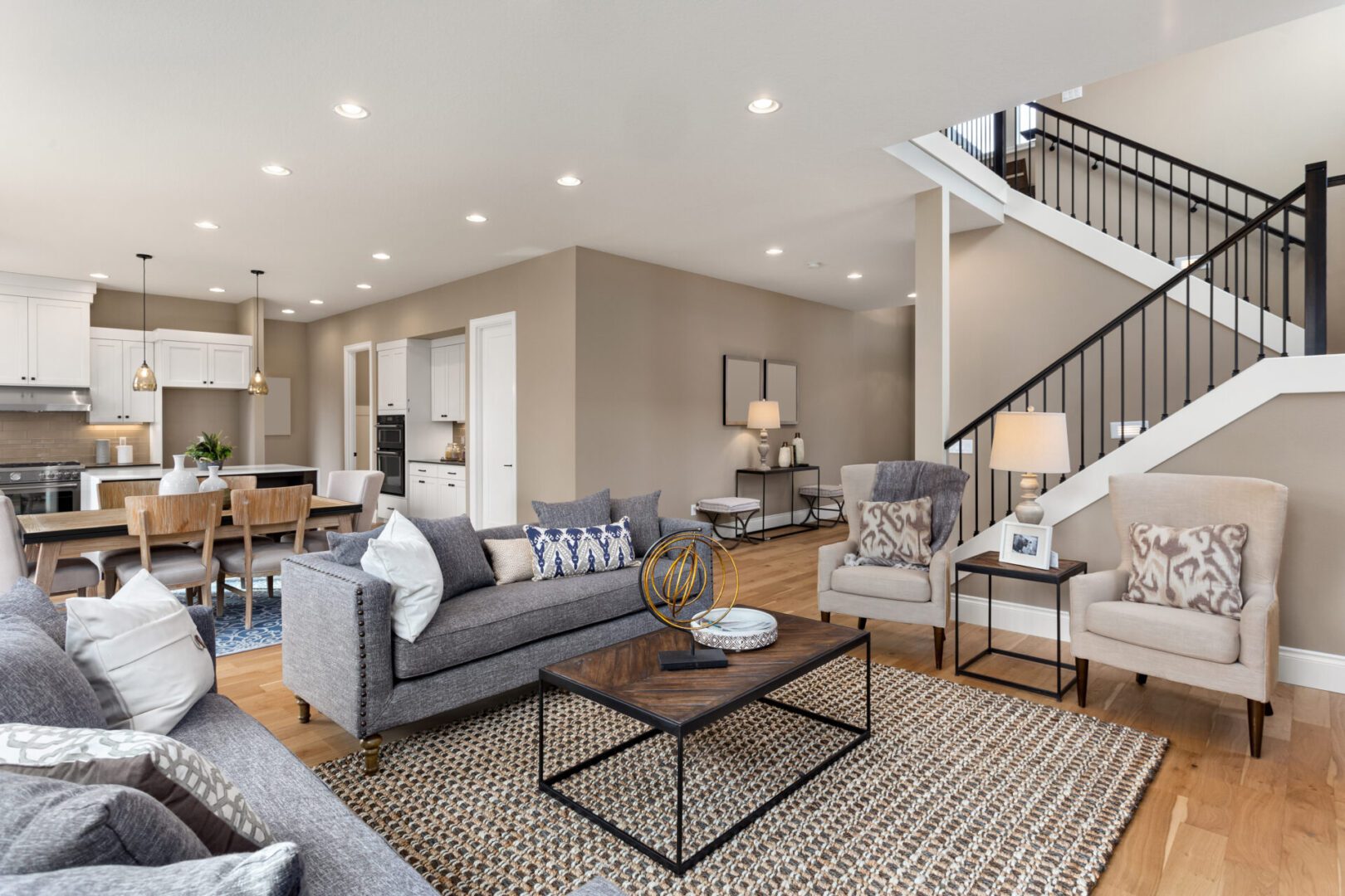 Beautiful living room interior with hardwood floors and and view of kitchen in new luxury home Modern open-concept living room with staircase.