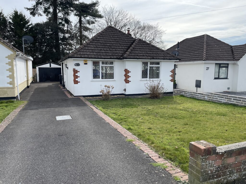 White bungalow with driveway and front yard.