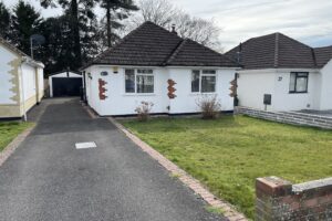 White bungalow with driveway and front yard.